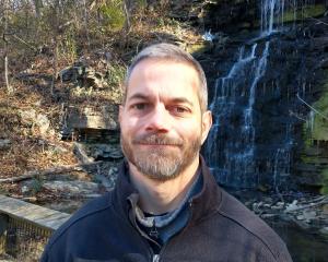 photo of John Johnson in front of a waterfall