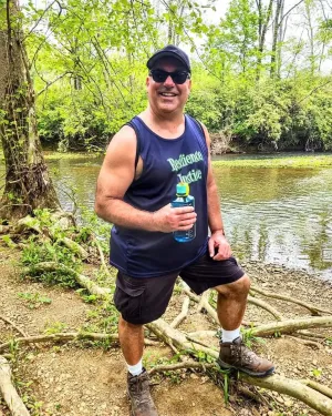 photo of Tony Arnold standing in the woods wearing a Resilience Justice tank