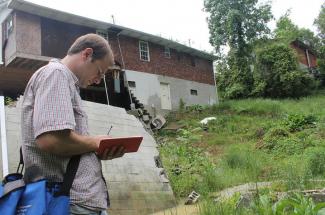 Matt Crawford inspecting landslide damage to a house
