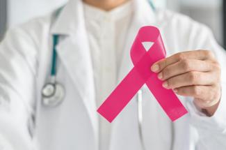 Doctor holding pink breast cancer ribbon