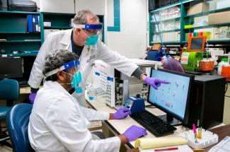 Photo of UK researchers Jerry Woodward and Siva Gandhapudi analyzing T cells 