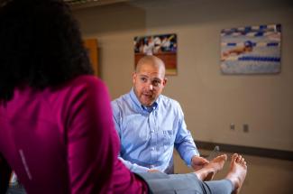 Photo of SMRI Associate Director Matt Hoch examining a patient's ankle inside the SMRI lab.