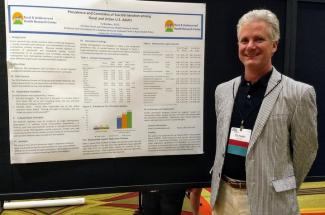 Photo of Dr. Ty Borders standing with his poster presentation