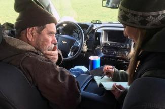 Photo of Richard Preston and Hanna Poffenbarger go over data from field trials in pre-pandemic times. 