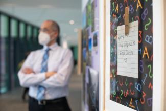 Nathan Vanderford, Ph.D., stands in front of the photo gallery exhibit in the UK Healthy Kentucky Research Building. The photo exhibit highlights work of ACTION program students. Pete Comparoni | UK Photo