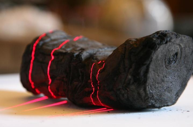 Herculaneum scroll with red laser lines being scanned at Institut de France by Brent Seales and his team.